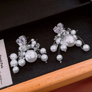 Detail view of pearl cluster earrings with zircon accents in a black jewelry box