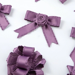 Détail de nœuds en ruban satiné violet à volants et roses en tissu pour bricolage