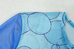 Detailed view of the mesh fabric with blue circular print and fine crewneck stitching