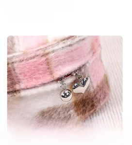 Detalle del neceser de felpa rosa a cuadros con cremallera de corazón y etiqueta