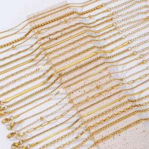 Set of 18K gold plated stainless steel bracelets in various chain styles on a stone stand