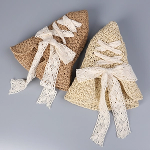 Detailed close-up of straw hats with white lace bow ties and vintage woven texture