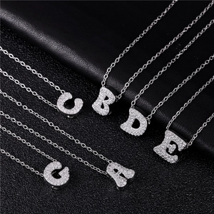 Detailed view of silver script letter pendants A-G with shimmering micro-pave zircons