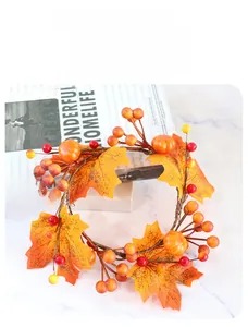 Detail of harvest candle ring with maple leaves, mini pumpkins and berries on marble