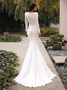 Detail of elegant back view bridal gown with satin buttons and mermaid train tail
