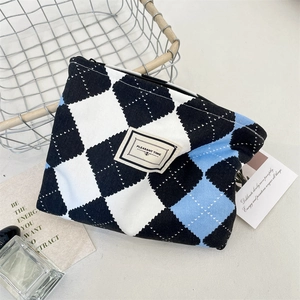 Detail of checkered makeup bag with zipper and Pleasant Time label on woven fabric