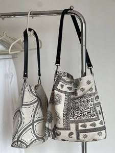 Detail view of cotton linen tote bags with paisley and geometric prints on hangers
