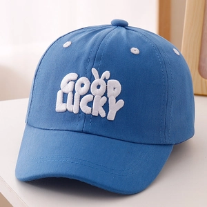 Détail d'une casquette bleue pour enfant avec broderie blanche Good Lucky et oreilles de lapin