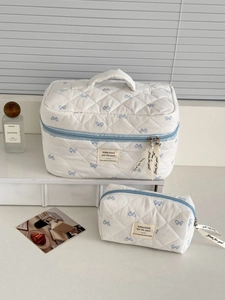 Quilted cotton cosmetic bag set with blue bow pattern and top handle for travel