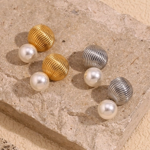 Detailed macro view of gold and silver hot air balloon earrings with faux pearls