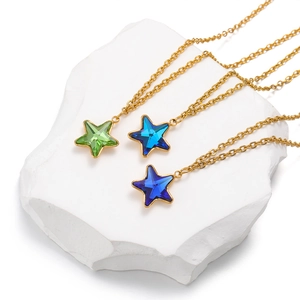 Stainless steel gold chain necklaces with colorful star-shaped crystal pendants on stone