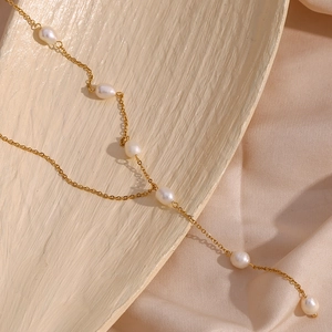 Detail of gold stainless steel Y-shaped necklace with freshwater drop pearls on silk