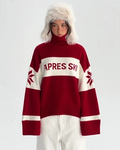 Detail of red and white striped knit sweater with Apres Ski text and snowflake patterns