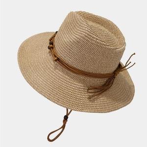 Detail of straw sun hat with brown braided rope, wooden beads and adjustable chin strap