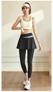 Front view of seamless yellow halter fitness top and black leggings with skirt detail