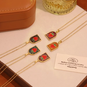 Vintage heart shield pendants in five enamel colors with gold chains displayed on leather