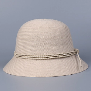 Close-up of fine knit texture and decorative rope on the beige summer sun bucket hat