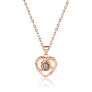 Rose gold heart projection necklace with sparkling stones on a white background