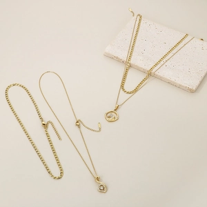 Detail of gold double-layer necklace with unicorn pendant and sparkling zircon stones