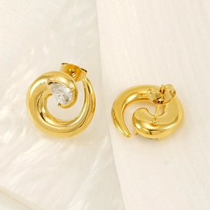 Golden spiral stud earrings with drop-shaped zircon on white textured background