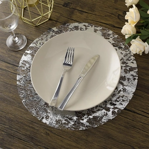 Macro shot of silver cutout placemat with intricate round lace texture on dark wood table