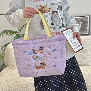 Purple quilted handbag with yellow handles featuring cute cartoon dog embroidery detail