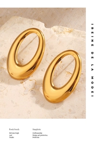 Macro detail of chunky gold hollow oval earrings with mirror polished finish on stone