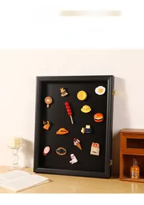 Detailed view of a black wooden magnetic frame displaying miniature food charms