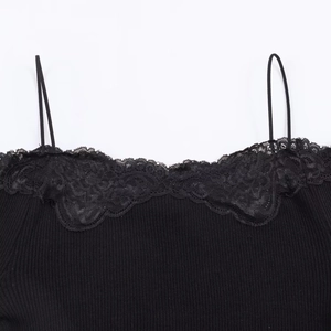 Close-up of black lace neckline and thin straps on ribbed knit camisole top