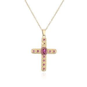 Close-up of 18K gold cross pendant with magenta zircon stones and detailed texture
