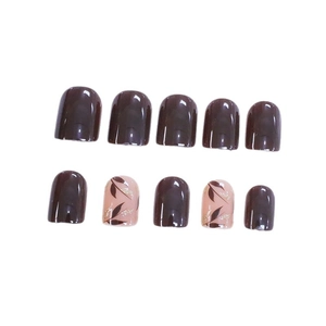 Short square press-on nails in chocolate brown and nude with leaf glitter designs