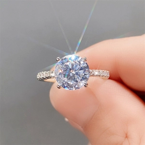 Macro shot of a brilliant round solitaire diamond ring with four-claw setting and pavé band