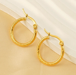 Detail of 18K gold-plated titanium earrings featuring a spiral texture and secure clasp