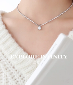 Macro shot of silver tennis necklace with single diamond pendant on female model