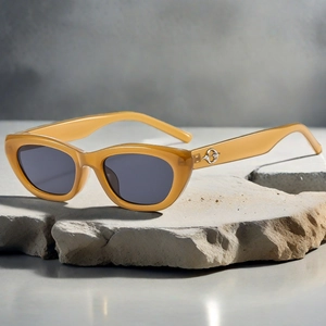 Close-up of retro cat-eye sunglasses with amber frames and silver hollow metal detailing