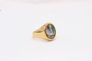 Detailed view of oval abalone shell inlay on golden stainless steel signet ring
