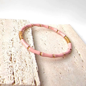 Detail view of pink enamel bamboo-style bangle with 18k gold plating on stone base