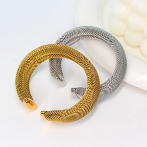Close-up of gold and silver mesh open cuff bracelets with smooth polished metal ends