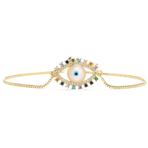 Detail of adjustable gold-plated bracelet featuring zircon evil eye and beaded accents