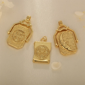 Three vintage gold plated religious pendants with St. Benedict and sun reliefs