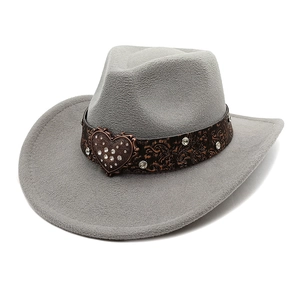 Close-up of embossed leather belt with rhinestone heart buckle on grey cowboy hat
