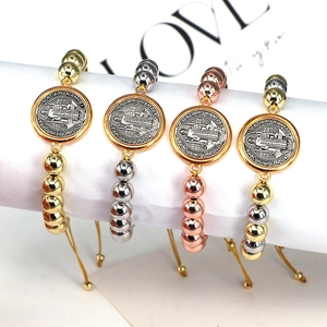 Detail of Saint Benedict religious medals on adjustable beaded bracelets in four metal finishes