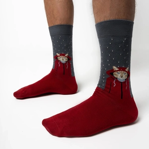 Detail of red and grey crew socks featuring a cute cartoon cat wearing a red hoodie