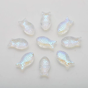 Macro detail of nine iridescent acrylic fish beads with scale texture for DIY jewelry