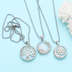 Detailed view of silver tree of life, dragon moonstone, and sun moon pendants