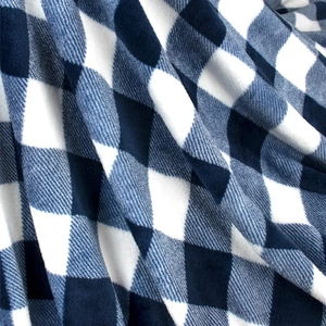 Close-up of soft flannel sherpa blanket with blue and white snowflake plaid texture