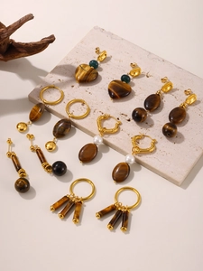 Macro shot of 18k gold plated stainless steel earrings with natural tiger eye stones