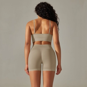 Detail of cross-back seamless sports bra and high-waist shorts in light khaki