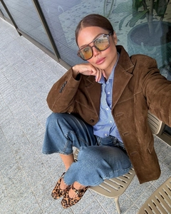 Detail view of retro burgundy suede blazer styled with blue striped shirt and leopard shoes