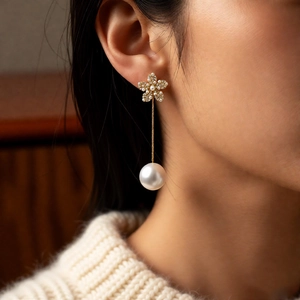 Elegant 18k gold plated flower stud with large pearl drop pendant worn by model
